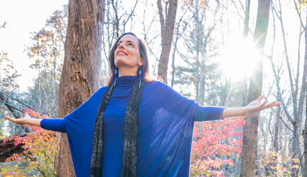 Woman in nature connecting with energy and light
